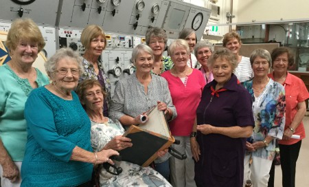 A group of older women looking at old nursing records